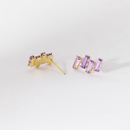 Vista dettagliata degli orecchini a bottone placcati in oro con cristalli viola che mostrano il design a posteriore.