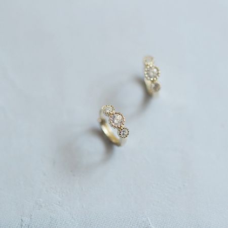 925 zilveren vergulde kleine huggie oorbellen met drie zirconia. - Een close-up van de 925 sterling zilveren vergulde huggie oorbellen, elk met drie sprankelende heldere zirconia edelstenen.