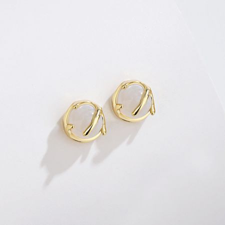 Scatto dettagliato degli orecchini a perno in argento sterling 925 placcati in oro con una pietra centrale in agata bianca.