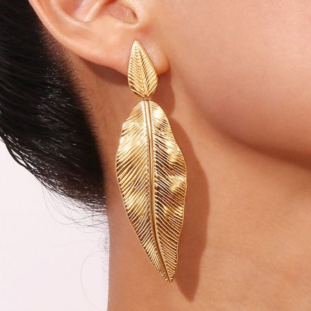 Boho Summer Gold-Plated Stainless Steel Leaf Drop Earrings - A close-up of a woman wearing a gold-plated stainless steel leaf drop earring, showcasing its bohemian summer style.