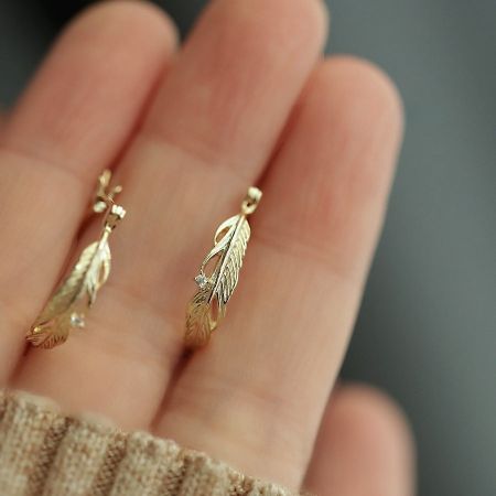 925 Sterling Zilver 14K Vergulde Veerblad Cubic Zirconia Oorringen - Een paar 925 sterling zilveren oorringen verguld met 14K goud, met een gedetailleerd veer- en bladontwerp, verfraaid met sprankelende cubic zirconia.