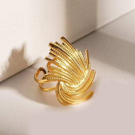 Vista dettagliata di un anello d'oro con un design testurizzato simile a una piuma.
