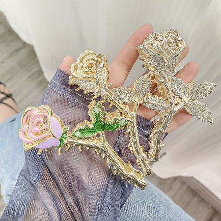A collection of three stunning rose-shaped hair clips in different designs and finishes.