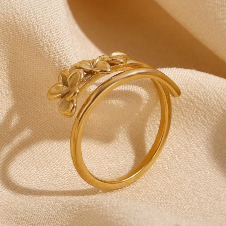 Dubbel gelaagde vergulde verstelbare roestvrijstalen bloemenvingerring set van 5 - Een close-up van de dubbel gelaagde vergulde roestvrijstalen bloemenring, die het ingewikkelde ontwerp van drie bloemen en de gepolijste afwerking toont.