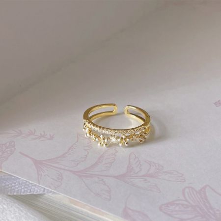 Detailed view of a single gold-plated daisy ring with a central zircon.