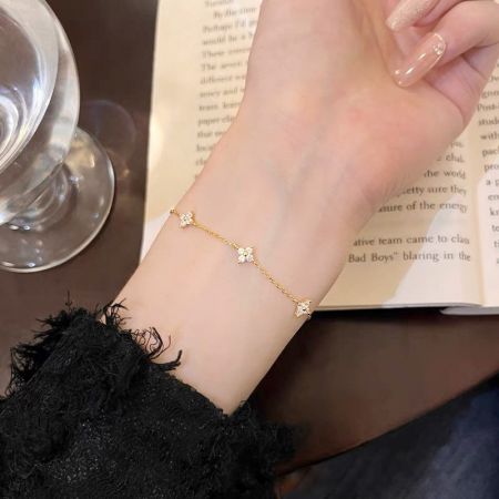 Detailed view of the gold-plated four-leaf clover charm bracelet.