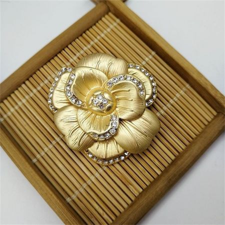 竹のトレイに優雅に展示されたヴィンテージの椿のブローチのセット。