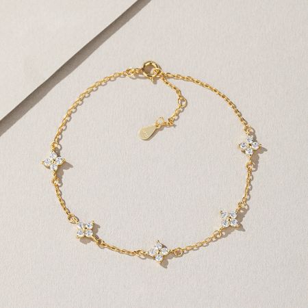 925 Sterling Zilver 18k Vergulde Klavertje Vier Zircon Sterren Armbanden - Een close-up van een 925 sterling zilveren, 18k vergulde armband uit een set, met een klavertje vier charm versierd met sprankelende witte zircon stenen.