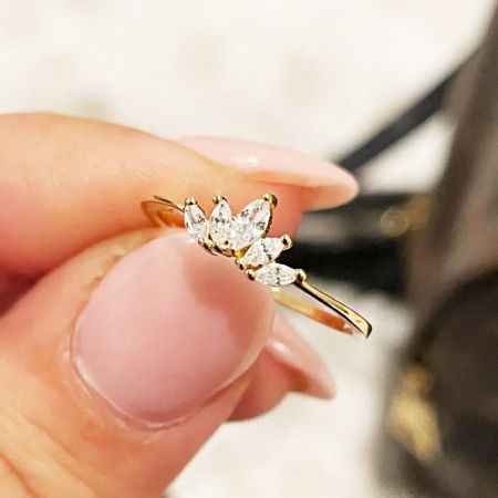5つの宝石のクラスターを展示する金の花のリングの詳細な上からのビュー。