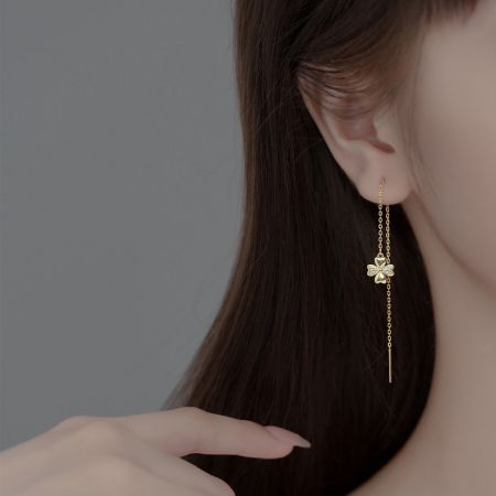 Een zijprofiel van een model dat de dangle chain oorbellen draagt, waarbij de lengte en beweging worden benadrukt.