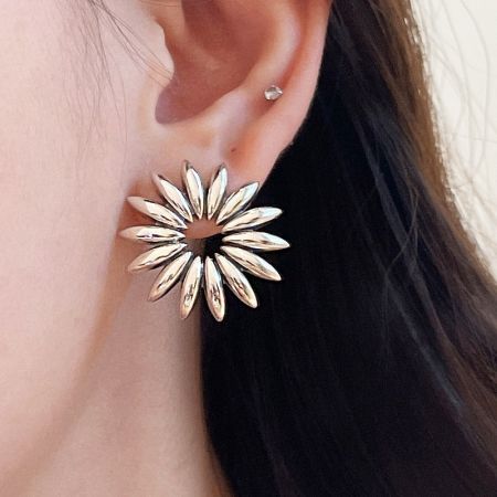 Modello che indossa un orecchino a bottone vintage a girasole in argento sterling 925.