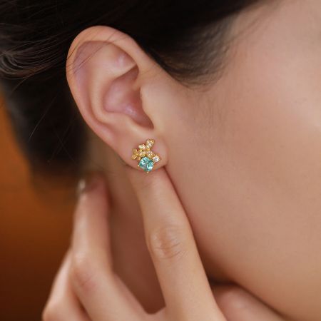Detailed view of the 18K gold plated butterfly earring featuring a sky blue cubic zirconia.