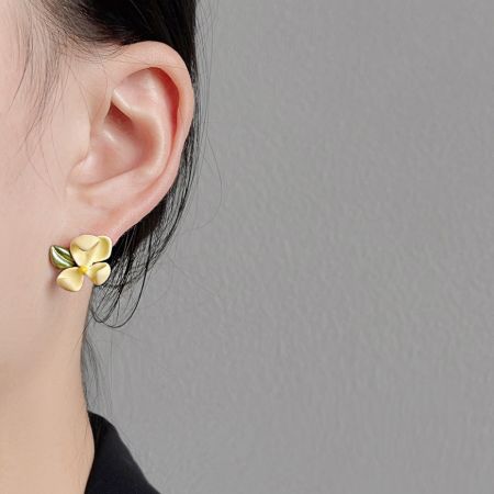 Gros plan de la boucle d'oreille en fleur de jasmin 3D sur l'oreille d'une femme.