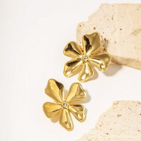 Een paar van de roestvrijstalen gouden bloemenoorbellen met schitterende diamantcentra.