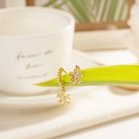 Eine andere Ansicht der goldenen blumenförmigen Ohrringe, die ihren Glanz zeigen.