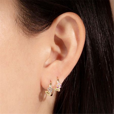 Model wearing the gold-plated sterling silver flower hoop earrings with sparkling cubic zirconia.
