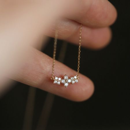 Toma detallada del colgante de flor de plata esterlina con acentos de zirconia brillante sobre un fondo neutro.