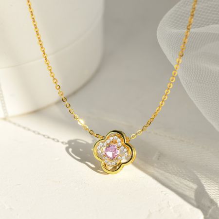 Collar de hoja de trébol de plata esterlina 925. - Un primer plano del collar de hoja de trébol de plata esterlina 925, mostrando el acabado bañado en oro y la piedra central de circonita cúbica rosa.