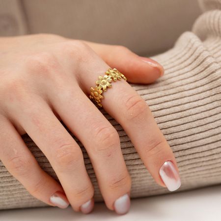 Modèle portant la bague ouverte en or en forme de tournesol pour montrer son ajustement réglable.