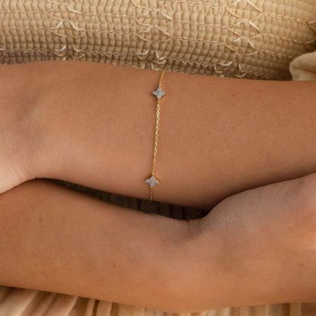 Primer plano de la pulsera de trébol dorado mostrando sus finos detalles.