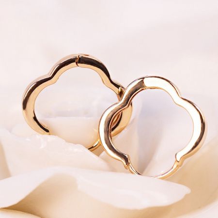 Aretes de aro de oro de trébol de cuatro hojas de plata esterlina 925 al por mayor - Una toma de estudio detallada de aretes de aro de plata esterlina 925 chapados en oro, diseñados en una delicada forma de trébol de cuatro hojas, ofrecidos por JR Fashion Accessories.