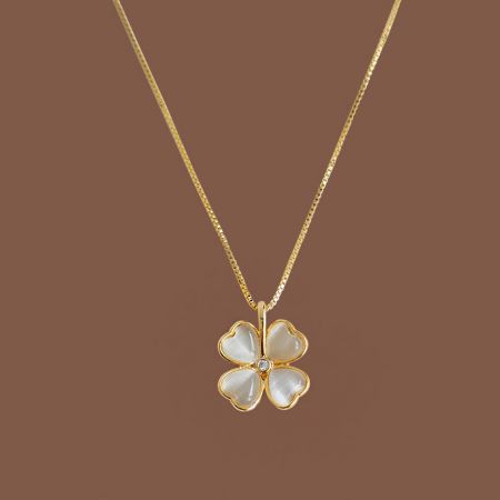 Gold necklace with a four-leaf clover pendant made from white cat-eye opal stone.