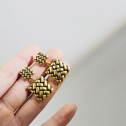 Detailed view of the woven geometric pattern on the gold-plated earrings.