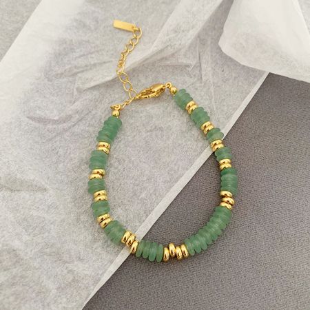 Una pulsera de cuentas verde y dorada con estilo del conjunto apilable inspirado en boho.