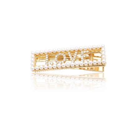 Clip de cabello con palabra personalizada - Un clip de cabello dorado personalizado de JR Fashion Accessories, que deletrea la palabra 'AMOR' con piedras de cristal incrustadas, mostrando la característica de palabra personalizada.
