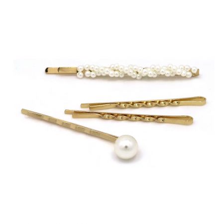 Close-up view of the gold hairpins with delicate pearl embellishments on a white background.