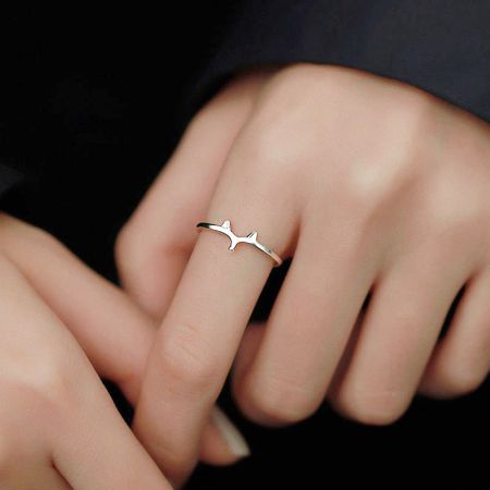 A unique gold-plated hammerhead shark ring on a finger, showcasing its detailed design.