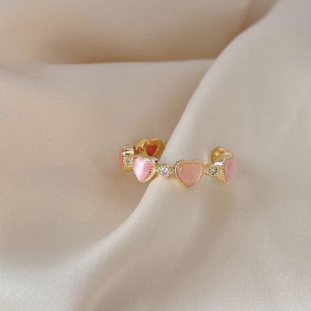 Elegant gold heart earrings with pink stones, complementing the ring set.