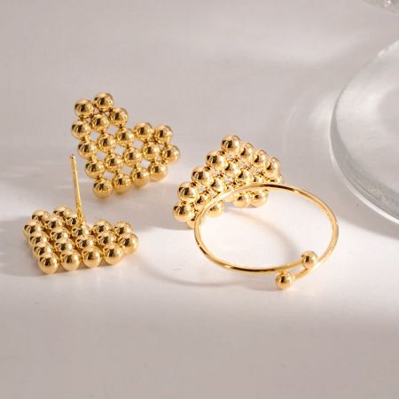 Brincos e pulseira em forma de coração com contas douradas combinando da coleção.