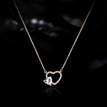 Collar de corazón hueco de zirconia en oro de plata esterlina 925 al por mayor - Primer plano de un collar de plata esterlina 925 con chapado en oro, que presenta un colgante de corazón hueco con una piedra de circonio en forma de corazón en el centro.