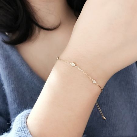 Otra vista de la pulsera de corazón de oro en una muñeca, destacando su diseño delicado.