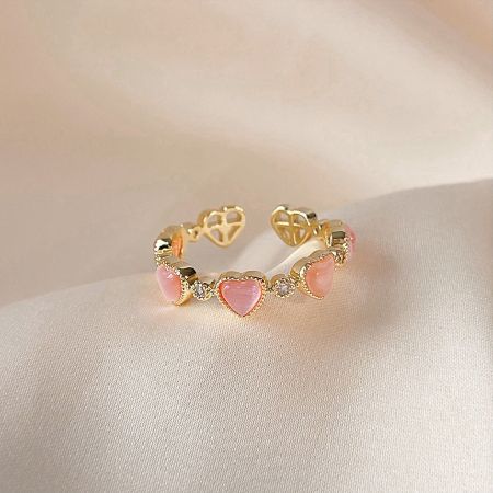 Matching gold bracelet with pink heart-shaped stones, part of the collection.