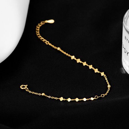 Close-up view of the gold heart-shaped charm bracelet.