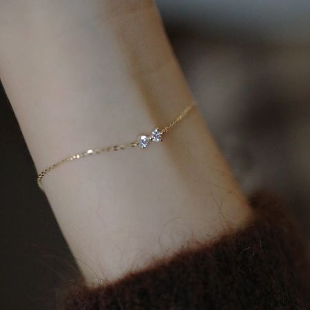 Conjunto de 5 Pulseras de Cadena de Cable con Lazo Elegante en Oro S925 - Un primer plano de la pulsera de cadena de cable con elegante lazo en oro S925 llevada en una muñeca, destacando su delicado diseño y material de plata esterlina.
