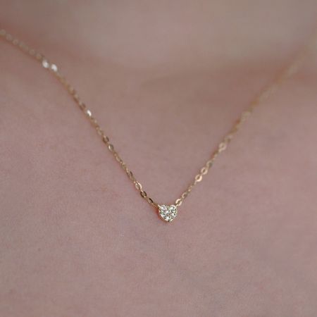 Detailed shot of the gold heart-shaped pendant, highlighting its sparkling diamond accents.