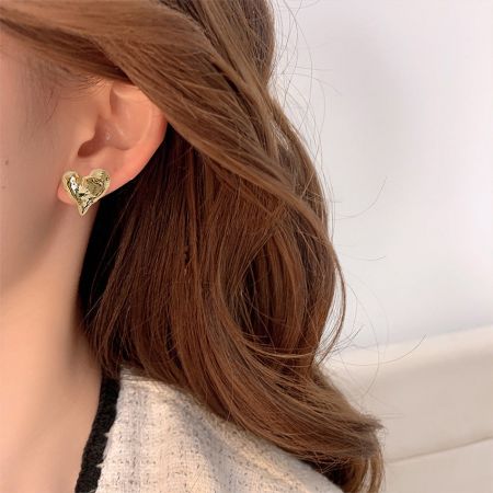 Modelo usando el pendiente de corazón de latón chapado en oro de 14K para mostrar escala y estilo.