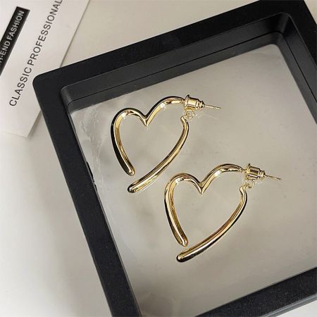 Pendientes de corazón elegantes chapados en oro de 14K exhibidos en una caja de joyería.