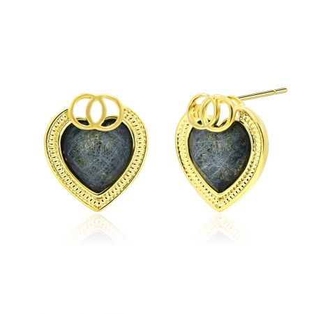 Vue latérale des boucles d'oreilles en forme de cœur en paillettes dorées montrant la texture et le matériau poly/résine gris foncé.