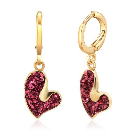 Une vue alternative des boucles d'oreilles en forme de cœur scintillant, mettant en valeur le brillant rouge vibrant à l'intérieur du pendentif en cœur plaqué or.