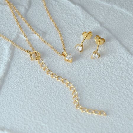 L'ensemble complet de bijoux en cœur doré, collier et boucles d'oreilles à clou.