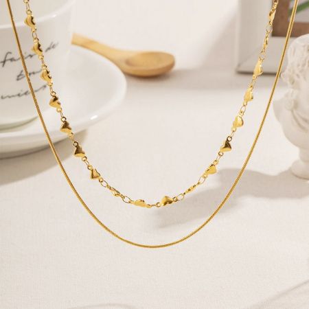 Nahaufnahme der goldenen doppellagigen Halskette mit herzförmigen Gliedern.