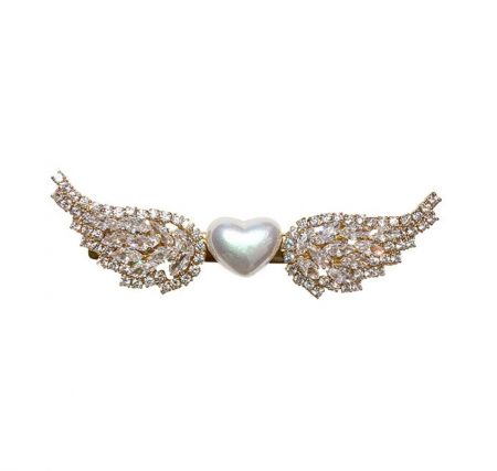 Pasador de cabello de perla con alas de ángel - Primer plano del pasador de cabello de perla con alas de ángel, mostrando la perla central en forma de corazón y las alas chapadas en oro adornadas con piedras preciosas transparentes.
