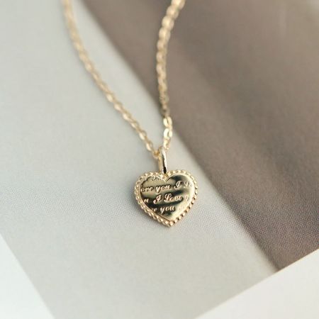Collar con Colgante de Corazón Delicado de Oro de Plata Esterlina 925 - Un primer plano del collar con colgante de corazón delicado de oro de plata esterlina 925, mostrando el intrincado texto grabado en el charm de corazón pulido.
