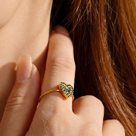 Ein stilvoller goldener Herzring mit grünem Zirkon, Teil eines fünfteiligen Sets.
