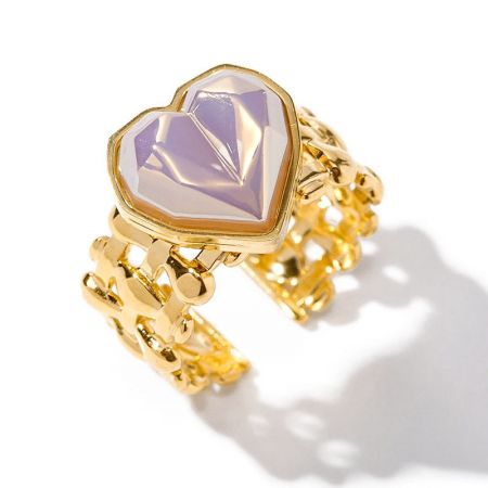 Outro ângulo do anel dourado de aço inoxidável com uma pedra coração roxa.