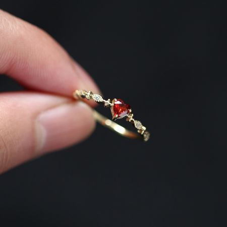 Vue détaillée de la bague en rubis en forme de cœur avec finition dorée.